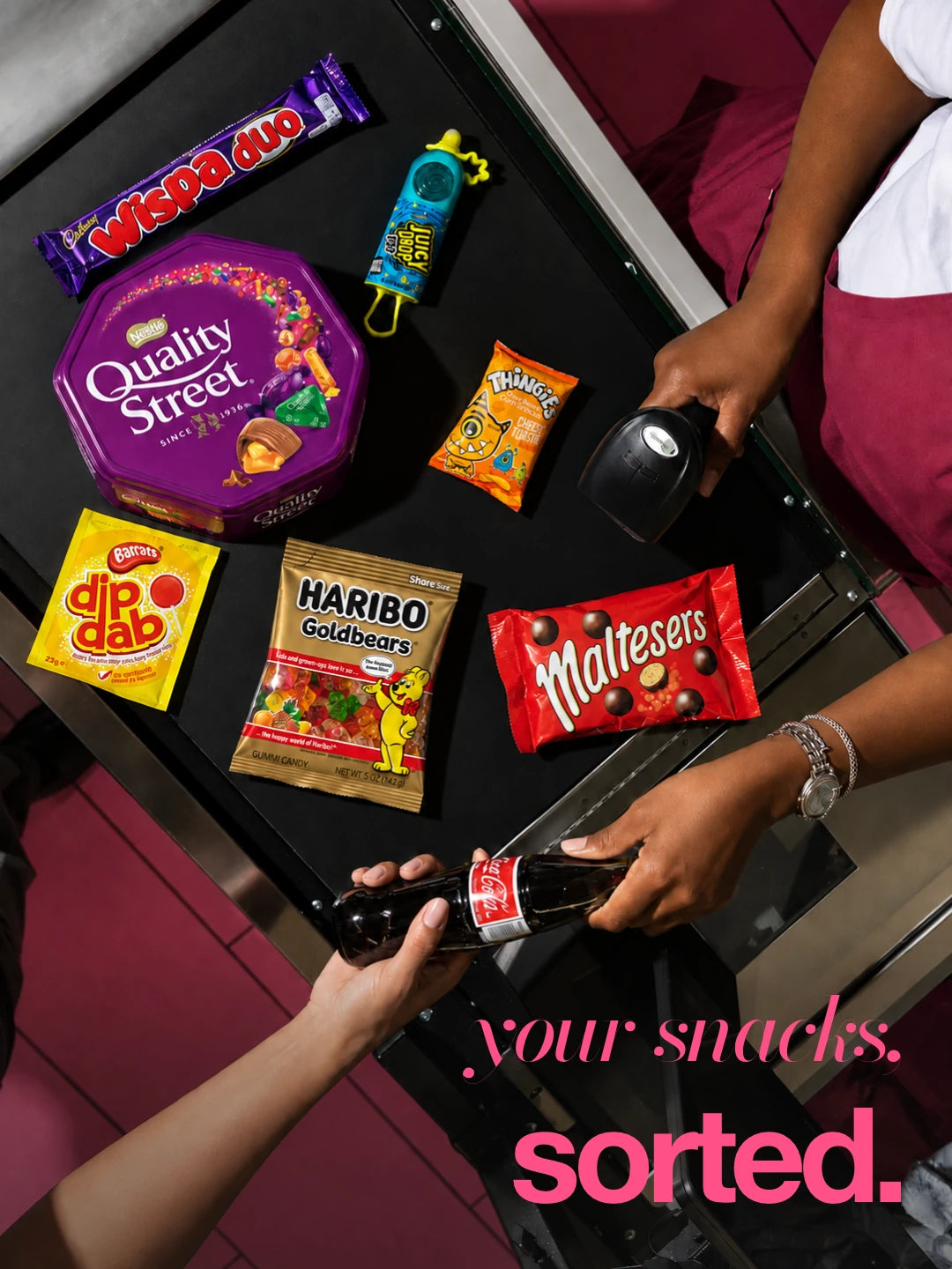 Your snacks, sorted: flash photograph of assorted packaged snacks at a pink checkout. Illustrative selection; contents vary.